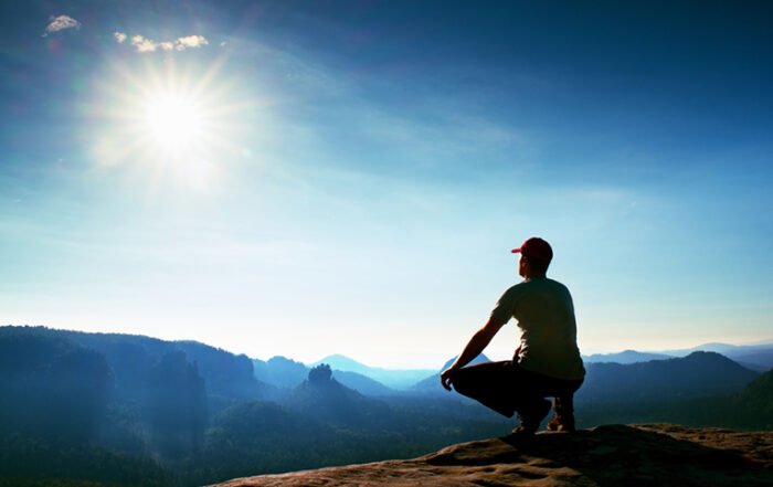 man squatting position looking at horizon