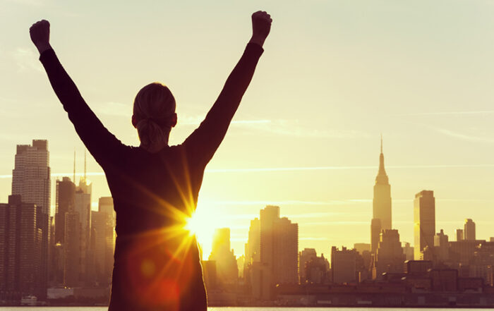 Silhouette of person viewing sunrise over New York City Skyline