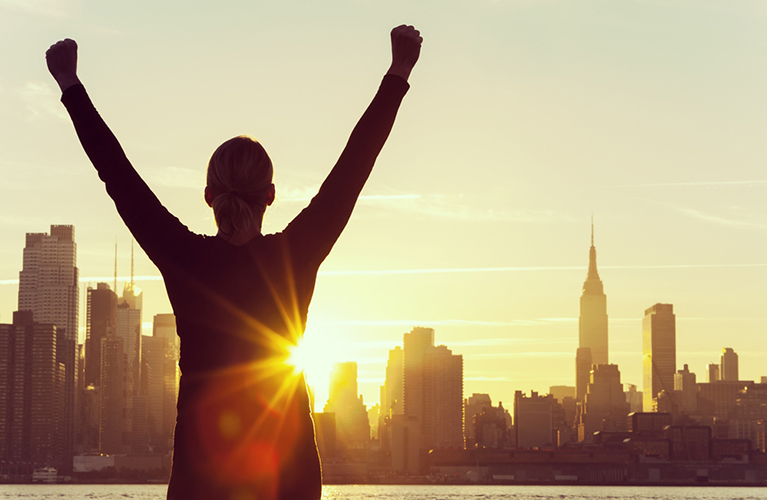 Silhouette of person viewing sunrise over New York City Skyline