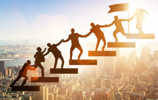 business people climbing steps holding hands