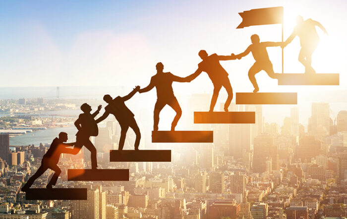 business people climbing steps holding hands